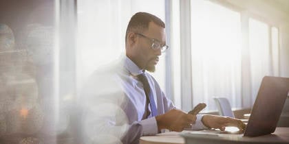 Man at desk on smart phone