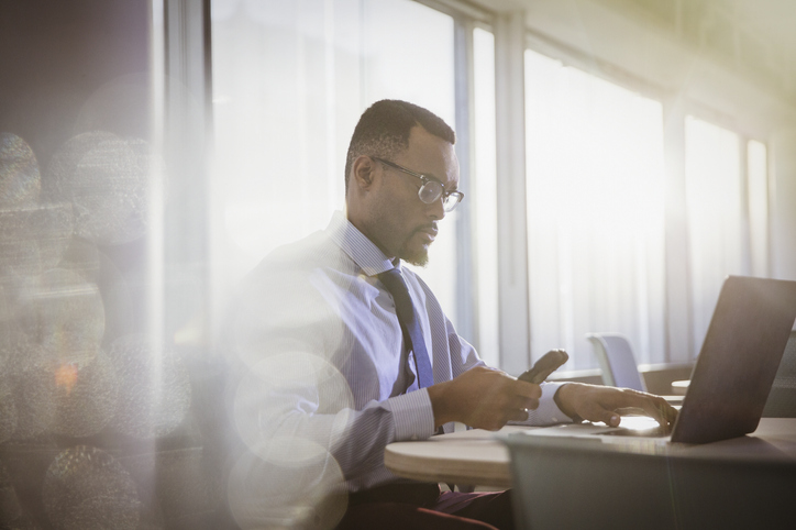 Man at desk on smart phone