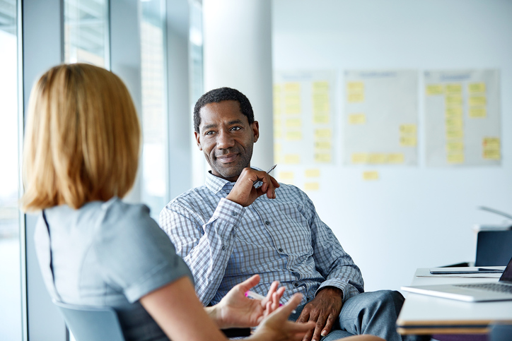 Man sitting talking to woman